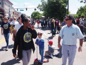 City Councilor Frank Baker marches in Fields Corner. Banner photo