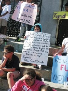 Students demonstrate for increased education funding in front of the State House. Photo credit: Saphia Suarez