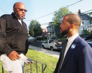 Hyde Park resident Lawrence Wyche chats with 14th Suffolk District candidate Segun Idowu. Banner Photo
