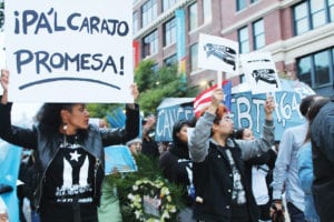 Protestors carry signs with Hurricane Maria’s death toll, 4,645 and counting, according to a report released in May by Harvard University. Photo: Catherine McGloin