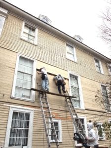 Workers replace clapboard siding on the Shirley Eustis House in Roxbury. Banner Photo