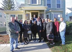 The party assembled at the McLaughlins’ family home gather in the front yard during the morning’s celebration. Mayor’s Office Photo by John Wilcox
