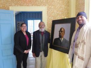 State Rep. Chynah Tyler, former Rep. Byron Rushing and Rodnell Collins with a painting of Malcolm X, who spent part of his childhood in Roxbury. BANNER PHOTO