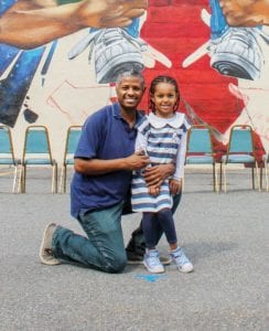 Asnake Zewdu and daughter pose in front of the mural. PHOTO: CELINA COLBY
