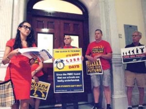 Standing outside the office of Senate President Karen Spilka, UMass Boston student Luz Johanna Perez Borbon reads from a bound volume of testimony on the need for education funding. BANNER PHOTO