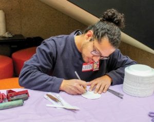 Volunteer Jiin Cruz works the booth for the event’s live community art making project. PHOTO: CELINA COLBY