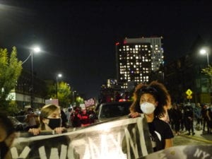 Demonstrators march down Tremont Street. Banner photo