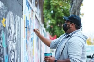 Kedrin Frias painting his mural featuring Nina Simone. PHOTO: CELINA COLBY