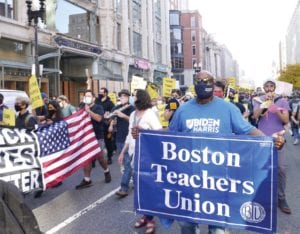 Boston Teachers Union Political Director Johnny McInnis marches in a victory celebration on Boylston Street. BANNER PHOTO