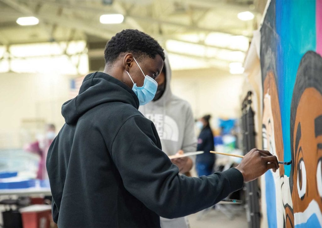 Student artists’ mural celebrates vaccine milestone at Reggie Lewis Center
