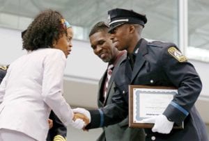 Acting Mayor Kim Janey greets newly sworn-in officer Carlton Alexander Williamson, president of the Boston Police Academy Recruit Class 60-20, as his father, Det. Carlton Williamson, looks on. PHOTO: ANGELA ROWLINGS