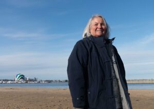 Maria Lyons, a retired science teacher, stands on Tenean Beach in Dorchester, Feb. 15. The beach, which sits at the mouth of the Neponset River, is a high-priority site for coastal resilience efforts from the city and state.